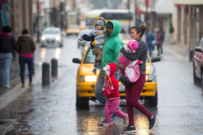 Personas cruzan la calle abrigadas ante el cambio climático en el noroeste de México.