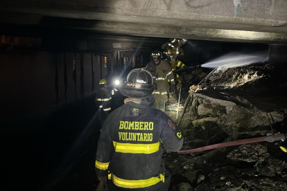 Bomberos realizan tareas de limpieza tras el incendio en la parte baja del Puente de la A, en el suroeste de Guayaquil.