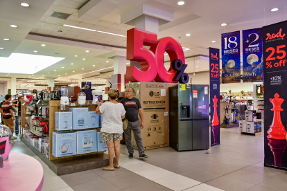 Varios clientes miran las ofertas que ofrece la tienda Sukasa, en el Mall de Sol, en Guayaquil.