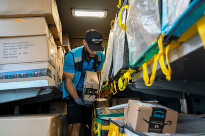 Un trabajador de la empresa Amazon organiza paquetes que se deben entregar.
