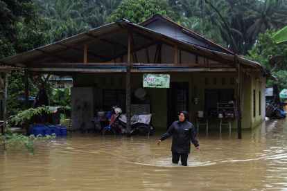 Una mujer camina por las aguas inundadas en Klang, en las afueras de Kuala Lumpur, Malasia, este lunes 24 de noviembre de 2025.
