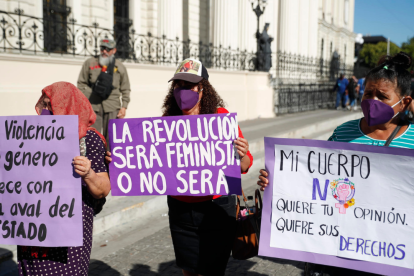 Manifestantes portan pancartas en San Salvador durante la jornada del Día Internacional para Erradicar la Violencia contra la Mujer.