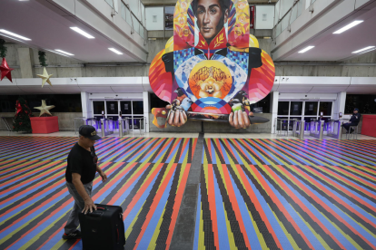 Pasajero camina frente a una imagen de Simón Bolívar en el aeropuerto de Maiquetía durante el plazo otorgado a las aerolíneas para retomar operaciones.