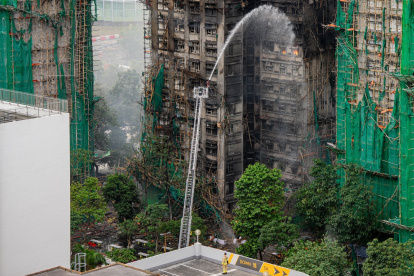 Los bomberos rocían agua sobre un apartamento en llamas en el distrito de Tai Po de Hong Kong, China, el 27 de noviembre de 2025.