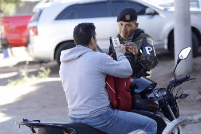 Un integrante de la Policía Militar de Honduras revisa el documento de un ciudadano en Tegucigalpa.
