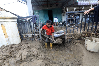 Residentes intentan limpiar su casa del barro en la zona de Meureudu , en banda Aceh, Indonesia.