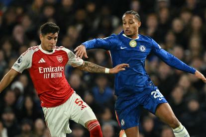 Piero Hincapié (i), del Arsenal, defiende un balón contra Joao Pedro, delantero del Chelsea.