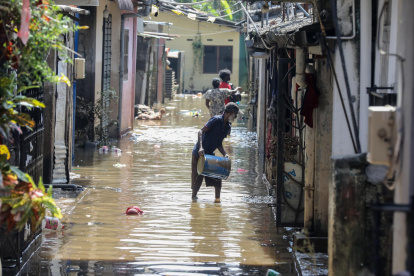 Personas afectadas por las inundaciones en Sri Lanka limpian su casa cubierta de barro y agua, el 3 de diciembre de 2025.