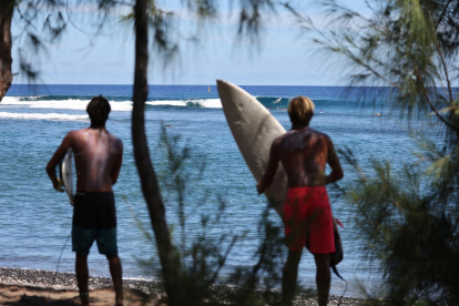 Los surfistas practican en el spot de surf de Saint-Leu, en la isla francesa de La Reunión, en el océano Índico, el 26 de marzo de 2021.