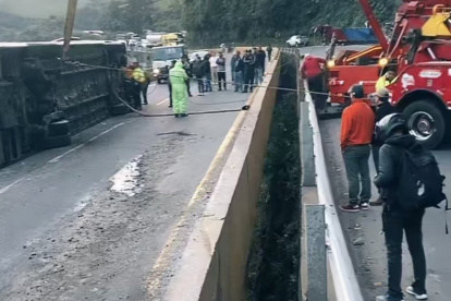 Los bomberos y la policía cercaron la zona del accidente en la vía Alóag - Santo Domingo, mientras se removía el bus volcado.