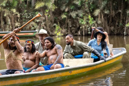 Integrantes de Nat Geo navegan junto a la comunidad Waorani en una embarcación tradicional amazónica.