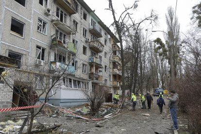 Trabajadores comunitarios ucranianos limpian escombros en el lugar donde un dron ruso atacó un edificio residencial de cinco plantas en Kiev, Ucrania, durante la invasión rusa.