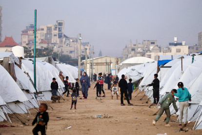 La gente camina entre los refugios en el campamento de Nuseirat para palestinos desplazados en el centro de la Franja de Gaza el 22 de diciembre de 2025.