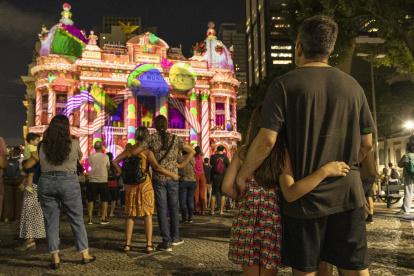 Personas observan la proyección navideña inspirada en el ballet clásico de Chaikovski, El cascanueces, en la fachada del Teatro Municipal de Río de Janeiro (Brasil).