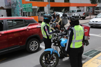 En la av. Diego de Almagro, norte de Quito, un agente civil de tránsito recuerda la normativa a un motociclista.
