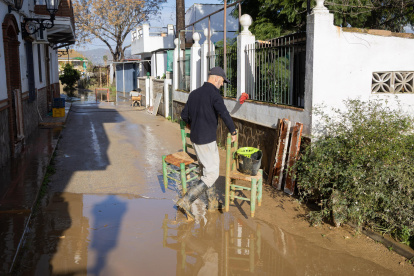 Un vecino en el sur de España, limpia de lodo y barro el interior de su vivienda ante la crecida del río Guadalhorce y las precipitaciones intensas tras decretarse la alerta roja.