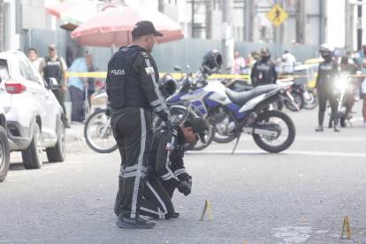 Agentes policiales recaban indicios tras el asesinato en los exteriores del hospital Teodoro Maldonado Carbo, en el sur de Guayaquil, este lunes 5 de enero.