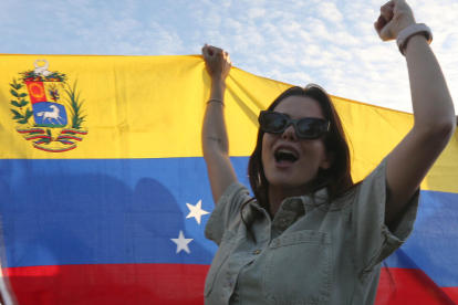 Una persona sostiene la bandera de Venezuela durante una manifestación este domingo 04 de enero, en Cancún (México), en un gesto de orgullo nacional y llamado a la democracia.