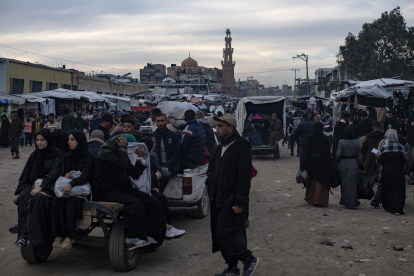 Palestinos desplazados caminan por una de las calles de la ciudad de Khan Younis en la franja de Gaza sur, 04 de enero de 2026, en medio de difíciles condiciones humanitarias.
