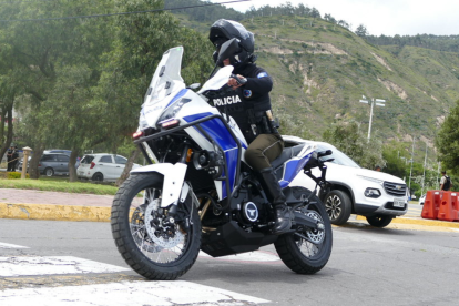 Un agente de la Policía Nacional patrulla en motocicleta una zona montañosa de Ecuador, en labores de vigilancia preventiva.