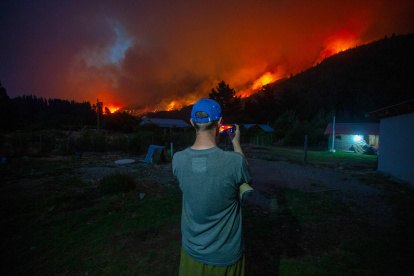 Un hombre toma una fotografía de los incendios forestales este miércoles, en el Hoyo provincia de Chubut (Argentina).
