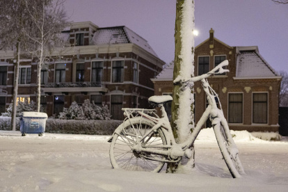 Una bicicleta cubierta de nieve está aparcada en las calles de Assen, en la provincia de Drenthe Países Bajos este viernes.