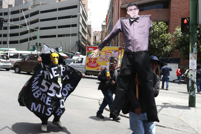 Una persona sostiene un muñeco con la imagen del presidente de Bolivia, Rodrigo Paz, durante una marcha este jueves en La Paz (Bolivia).