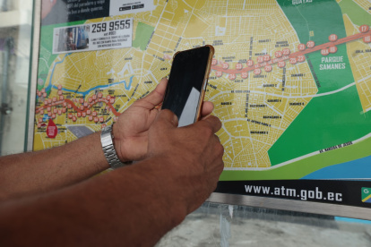 Ciudadanos buscan revisar en sus celulares las rutas de buses urbanos que transitan por el norte de Guayaquil.