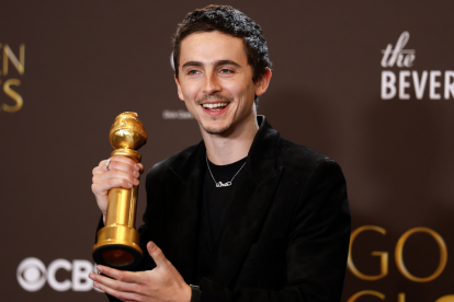 Timothee Chalamet posa con el premio a la mejor interpretación masculino en una película - musical o comedia por "Marty Supreme".