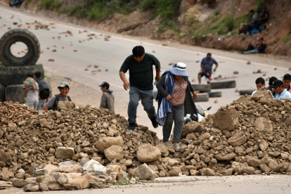 Personas caminan en medio de una carretera bloqueada este viernes, en Cochabamba (Bolivia).