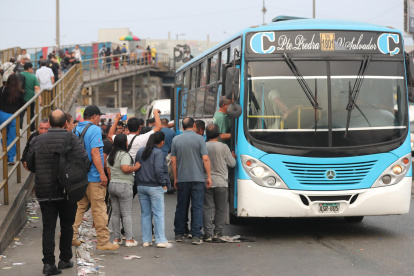 Personas hacen fila para subir a un bus este miércoles, 14 de enero de 2026, en Lima (Perú).
