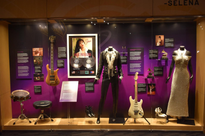 Fotografía que muestra vestidos e instrumentos pertenecientes a la difunta artista Selena Quintanilla durante la muestra titulada "Selena From Texas to the World".