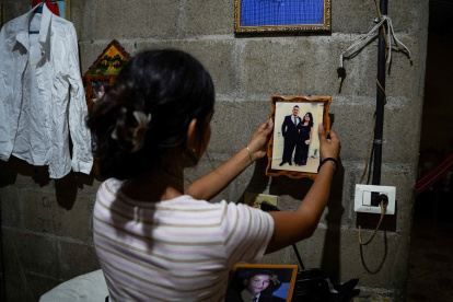 Jade, de 16 años, sostiene una fotografía de su padre, José Roger Urquilla, en su casa en El Rosario, El Salvador, el 3 de diciembre de 2025.