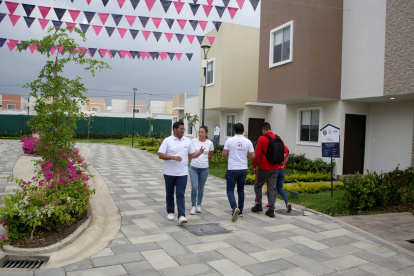Un grupo de personas visitan y revisan los inmuebles que se venden en la vía a la costa, donde se ofrecen casas de interés social.