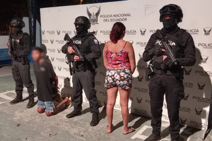 Policías armados custodian a los dos detenidos durante el operativo “Libertad 24” en Muisne, sur de la provincia de Esmeraldas.