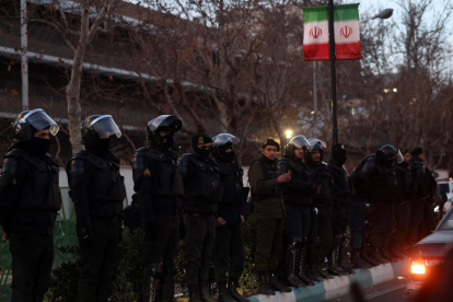 La policía antidisturbios iraní vigila mientras los estudiantes protestan frente a la embajada británica en Teherán, Irán, 14 de enero de 2026.