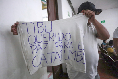 Un hombre desplazado por la violencia mostrando una camiseta con una nota escrita pidiendo paz para el Catatumbo en Cúcuta (Colombia).