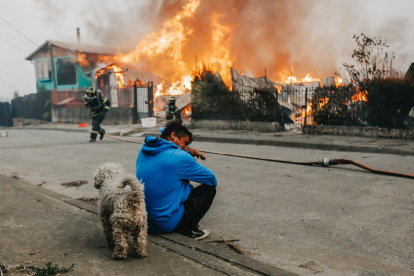 Un hombre observa casas afectadas por incendios forestales este domingo, en Penco (Chile).