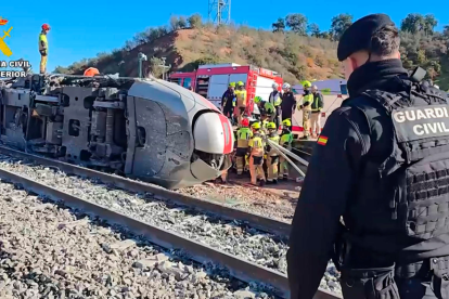 Guardia Civil y bomberos trabajan entre los restos del tren tras el choque en Córdoba.