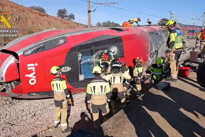 Bomberos trabajan en la cabecera del tren Iryo que descarriló ayer e impactó contra un Alvia, dejando al menos 39 víctimas mortales.