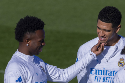El delantero del Real Madrid, Vinícius Jr (i) bromea con el centrocampista Jude Bellingham (d) durante el entrenamiento de Real Madrid el lunes 19 de enero de 2026.