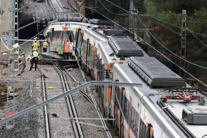Bomberos en el lugar donde al menos una persona murió y cinco resultaron gravemente heridas cuando un tren de servicio regional chocó contra un muro derrumbado entre Sant Sadurni d"Anoia y Gelida, cerca de Barcelona.
