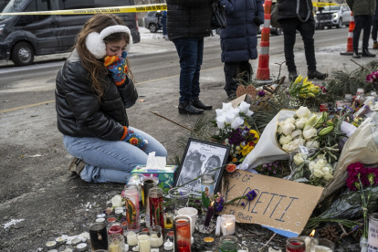 Una residente local se arrodilla y llora mientras visita un monumento improvisado en la zona donde Alex Pretti fue asesinado a tiros por agentes federales de inmigración en Mineápolis.