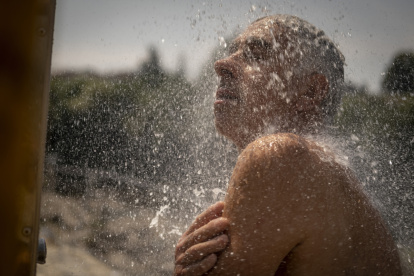 En la imagen de archivo, un hombre se refresca en una ducha en las termas de A Chavasqueira, en Ourense, España.