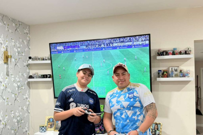 Ahidam (i) y su padre comparten la afición por Emelec y el fútbol hasta en los videojuegos.
