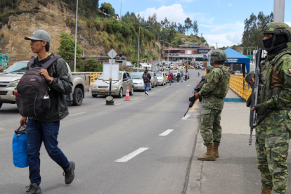 Militares ecuatorianos vigilan el puente internacional de Rumichaca, en Tulcán, ante el aumento de tensiones fronterizas.