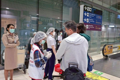 Funcionarios de salud en Tailandia controlan la temperatura de pasajeros internacionales en el aeropuerto de Suvarnabhumi, Bangkok.