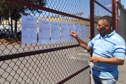 Freddy Rojas, empleado despedido de Aucas, deja notificaciones en la puerta del estadio.