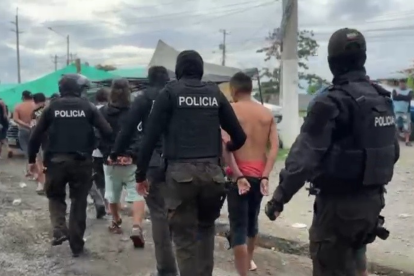 Policías escoltan a seis detenidos durante un operativo en Durán, revelado por un dron policial.