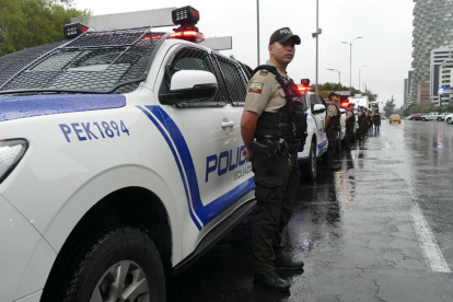 Policías permanecen junto a patrulleros durante un operativo de seguridad en Quito.